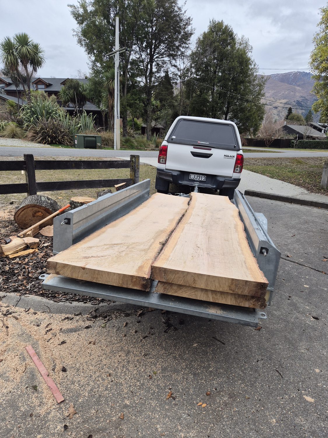 Freshly milled timber slabs loaded on a trailer behind a ute